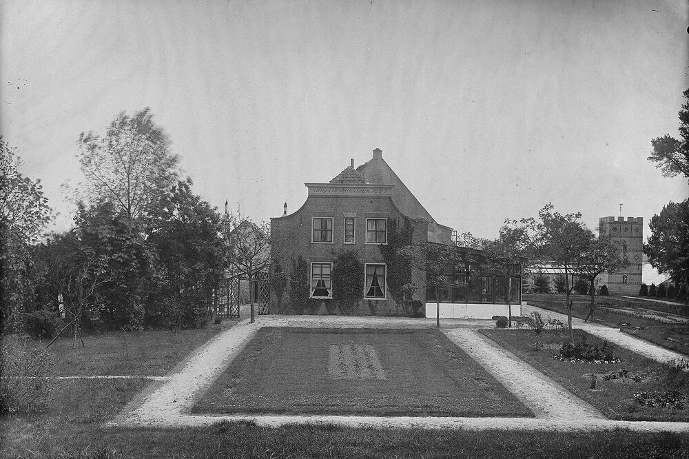 Zwart-witfoto van het buitenhuis Walesteyn bij Rockanje met een formele tuin en vijver ervoor